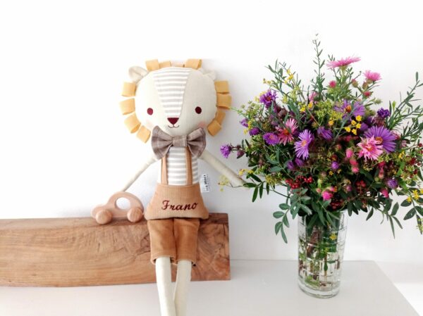 Krpena lutka lavić pored vaze s cvijećem